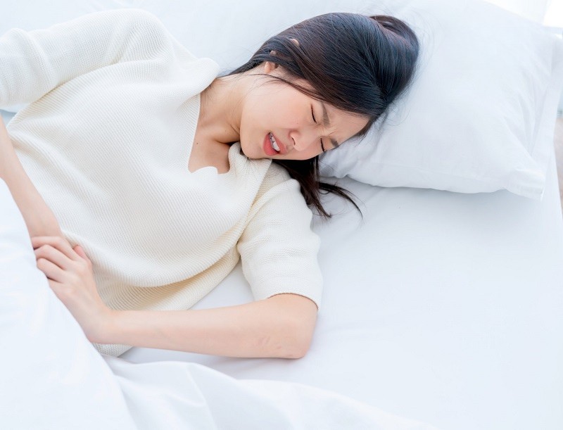 Đau bụng dưới dữ dội là một trong triệu chứng của rối loạn kinh nguyệt sau khi phá thai khiến chị em mệt mỏi